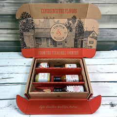 This gift set includes: The Original Roasted Raspberry Chipotle Sauce Texas Whiskey Glaze Bacon Chipotle BBQ Sauce Brat Haus Beer Mustard Fredericksburg Peach Jam Cheese spreader knife